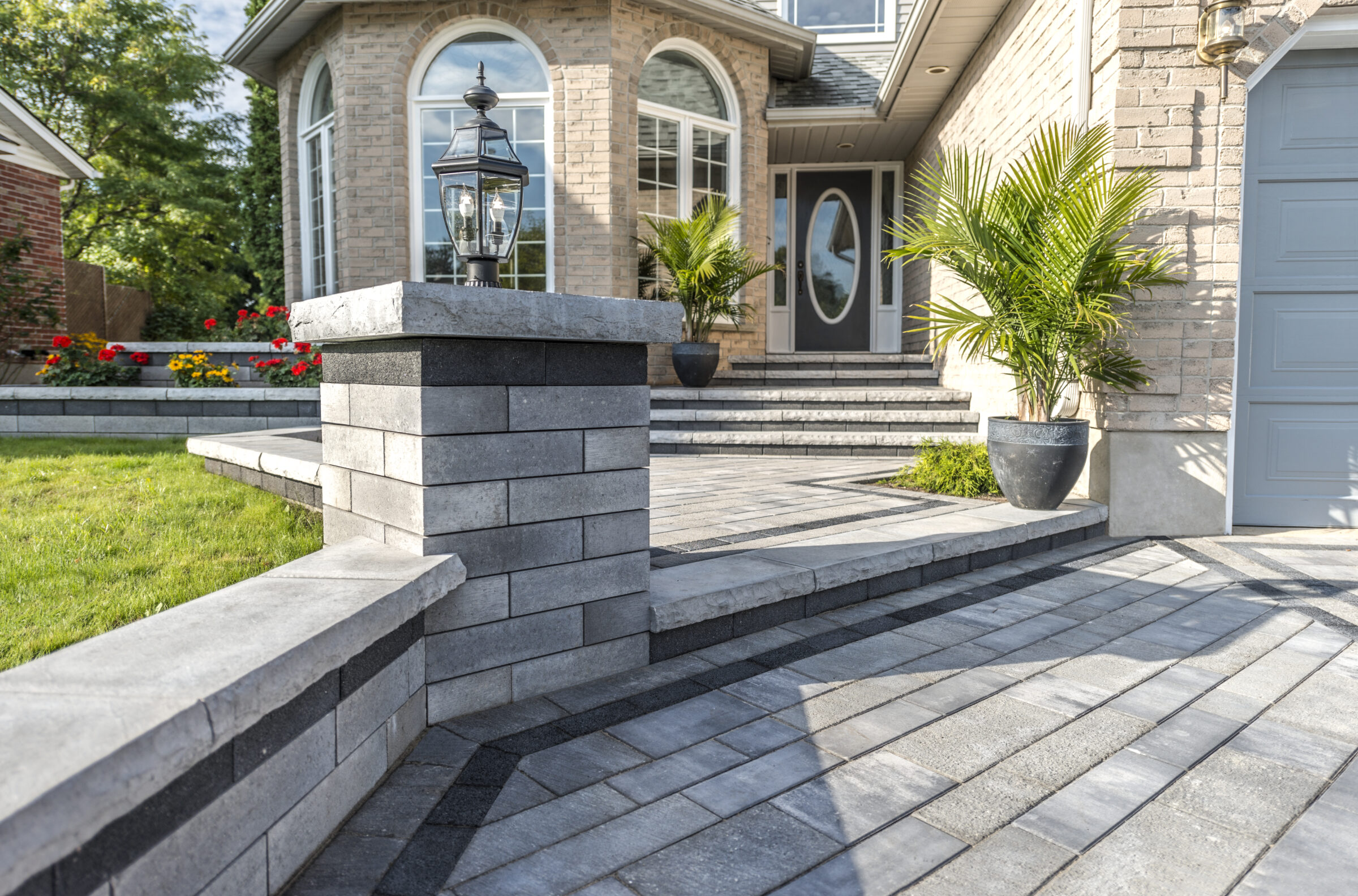 Modern house entrance with stone pathway and plants.