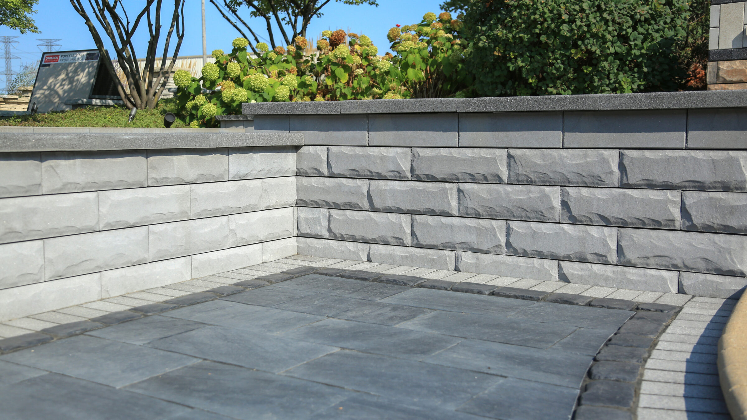 Stone retaining wall with paver walkway and plants