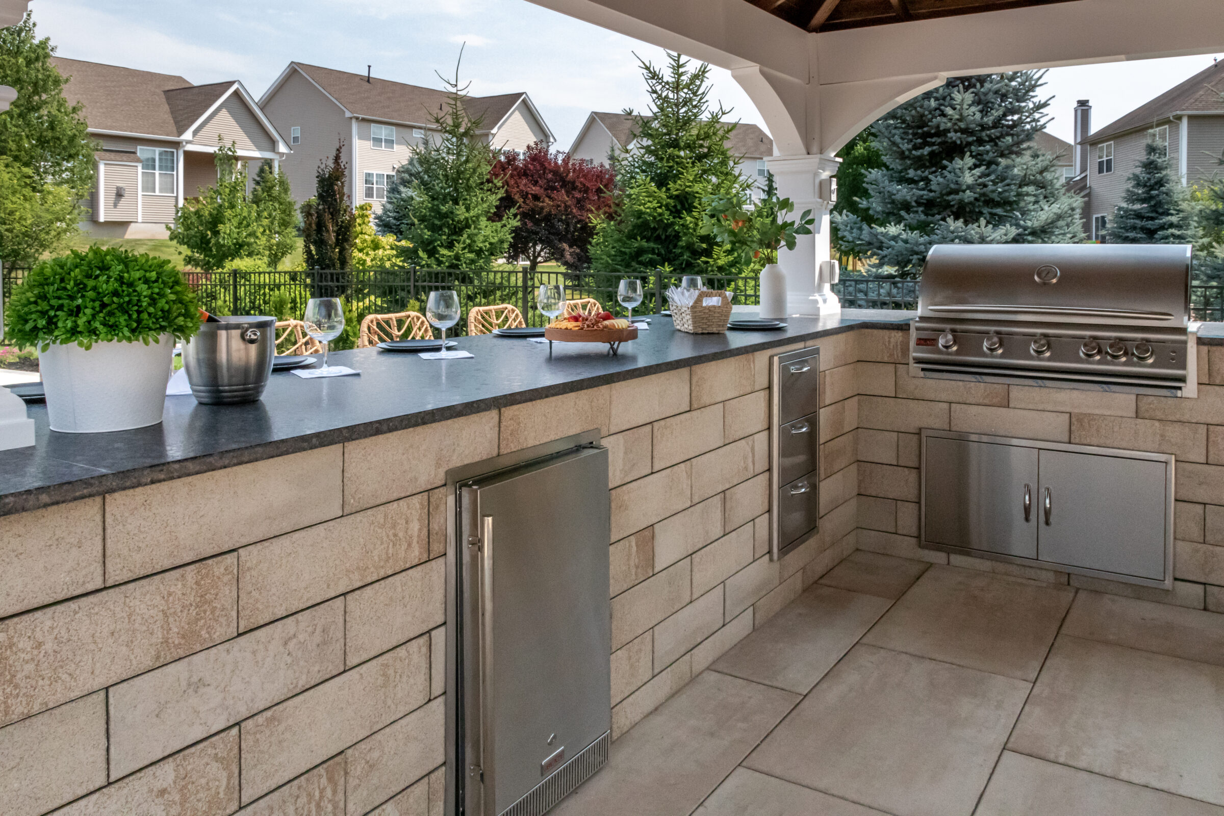 Outdoor kitchen with grill and seating area.