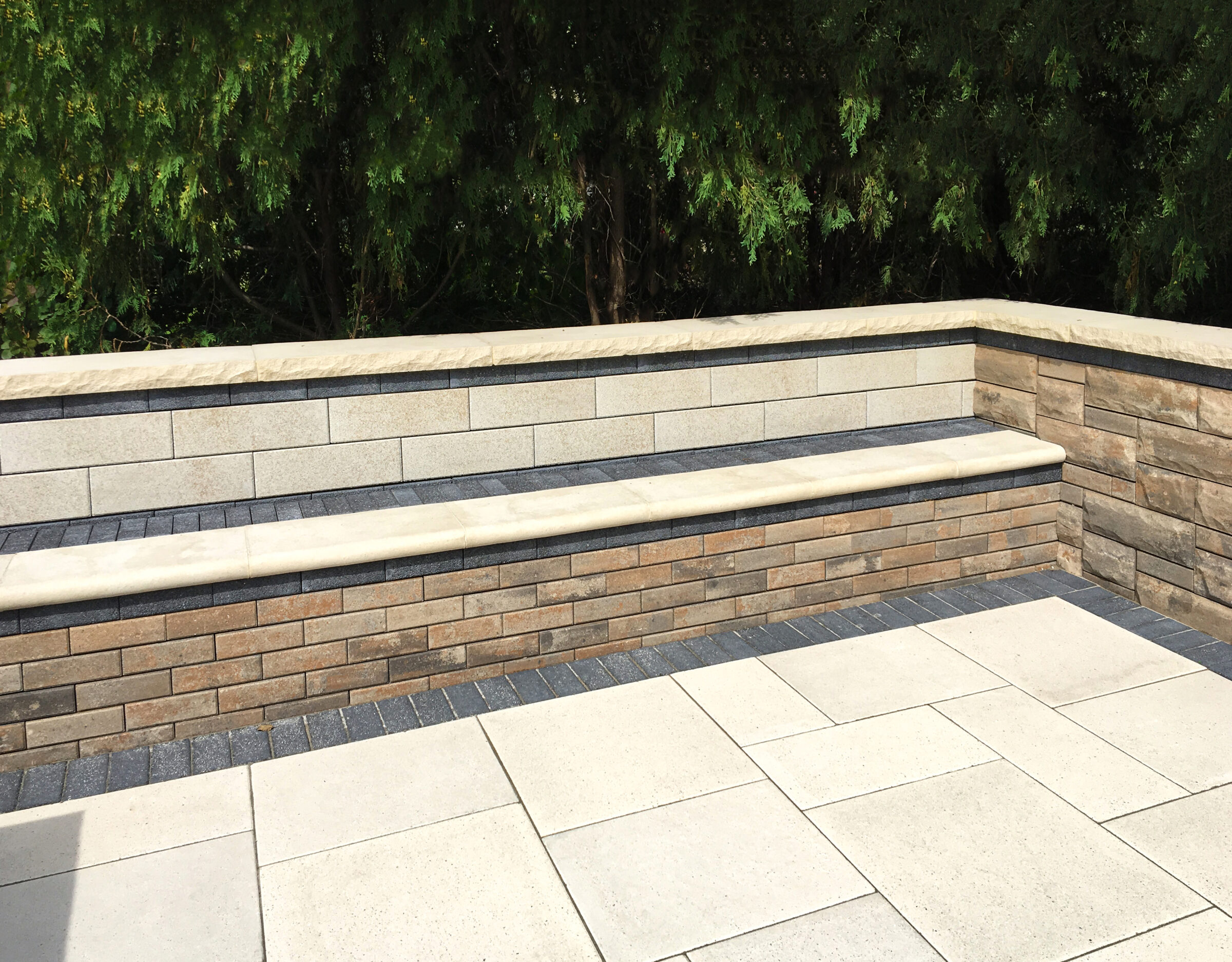 Stone bench with brick wall and patio floor.