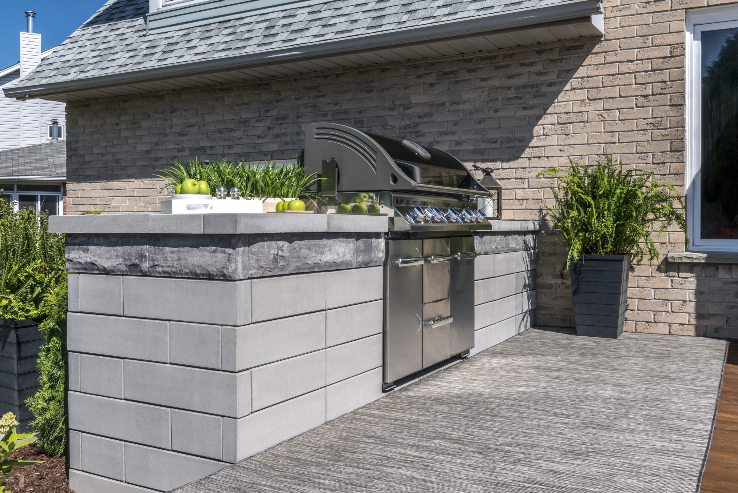 Outdoor kitchen with modern grill and planters
