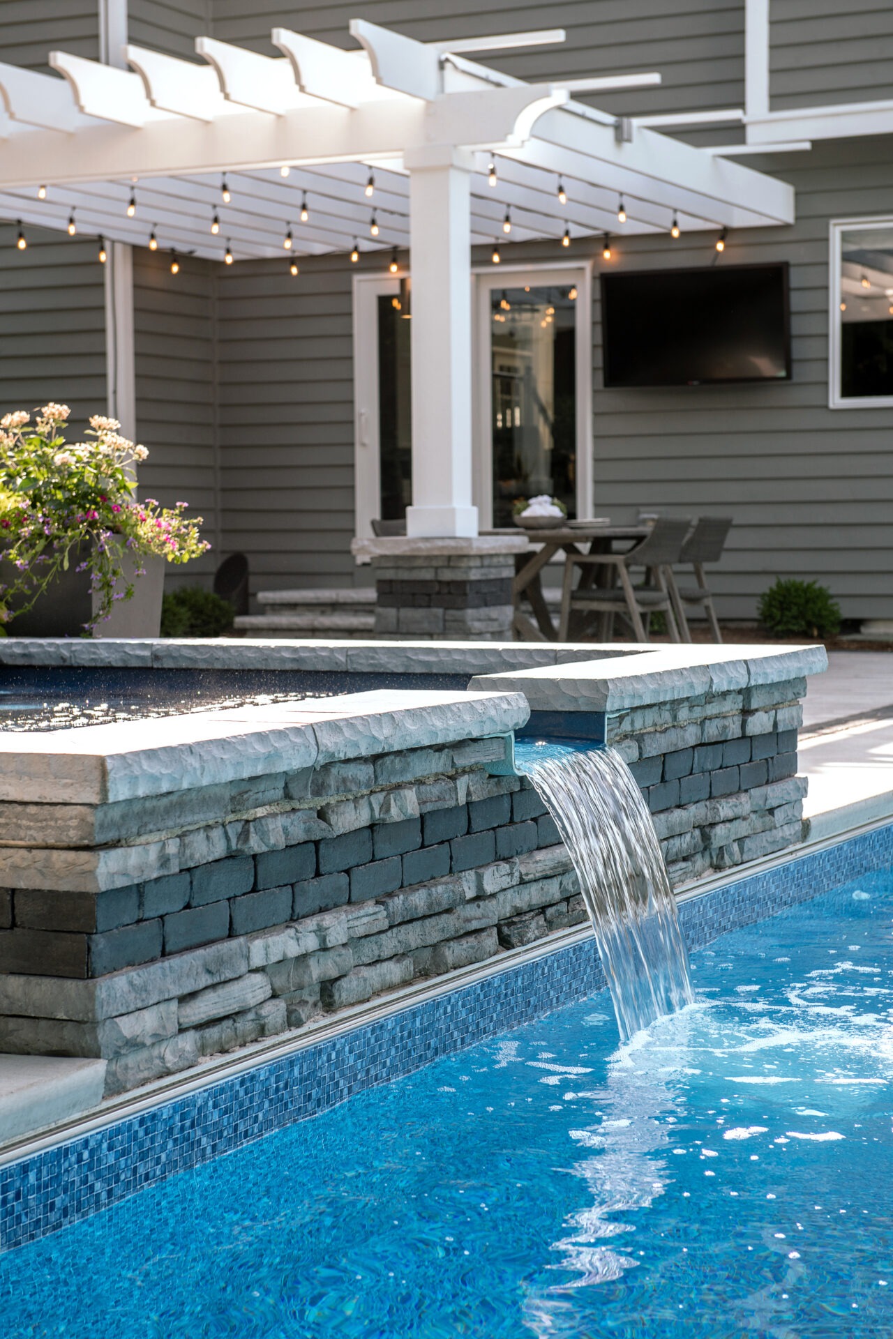 Modern backyard pool with waterfall feature.