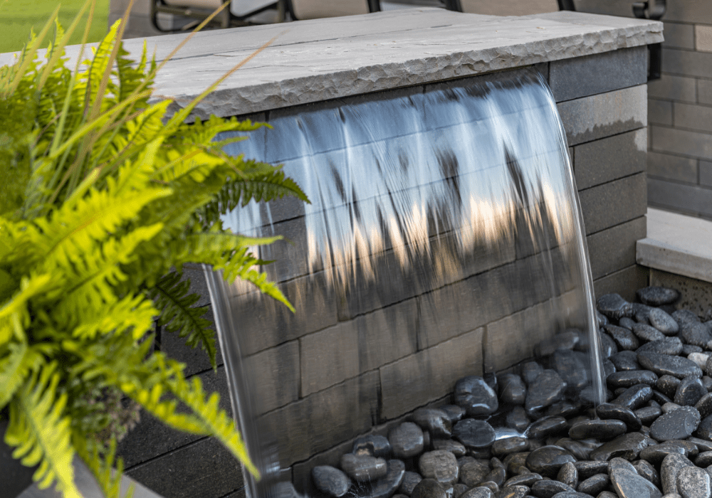 Modern waterfall feature with rocks and plants.