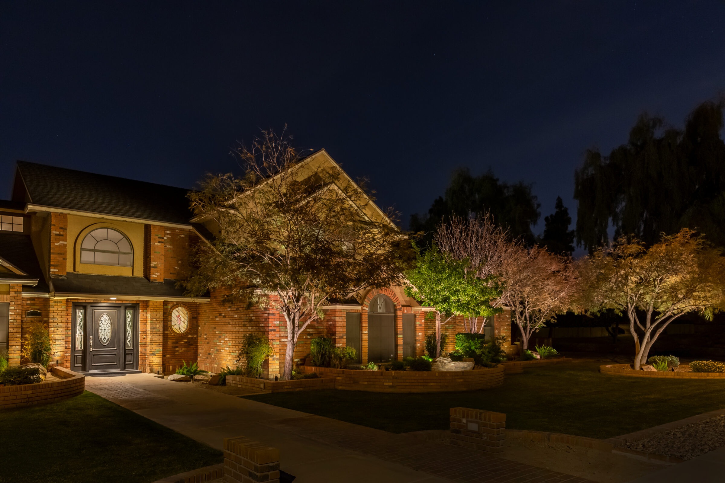 Brick house with garden lights at night