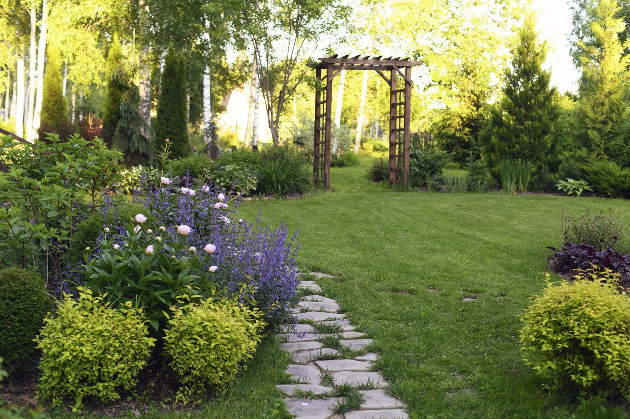 Lush garden with flowers and wooden archway pathway