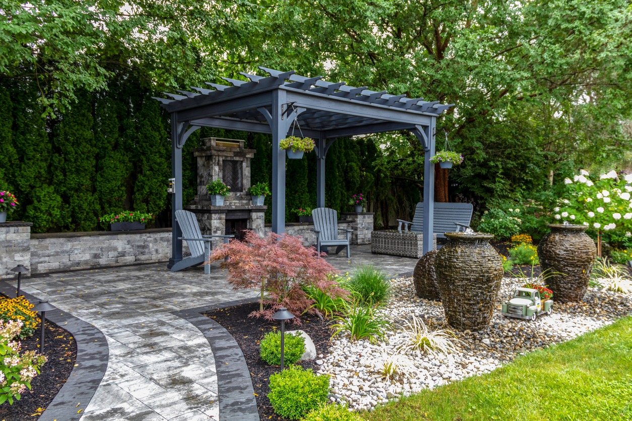 Garden pergola with chairs and decorative plants.