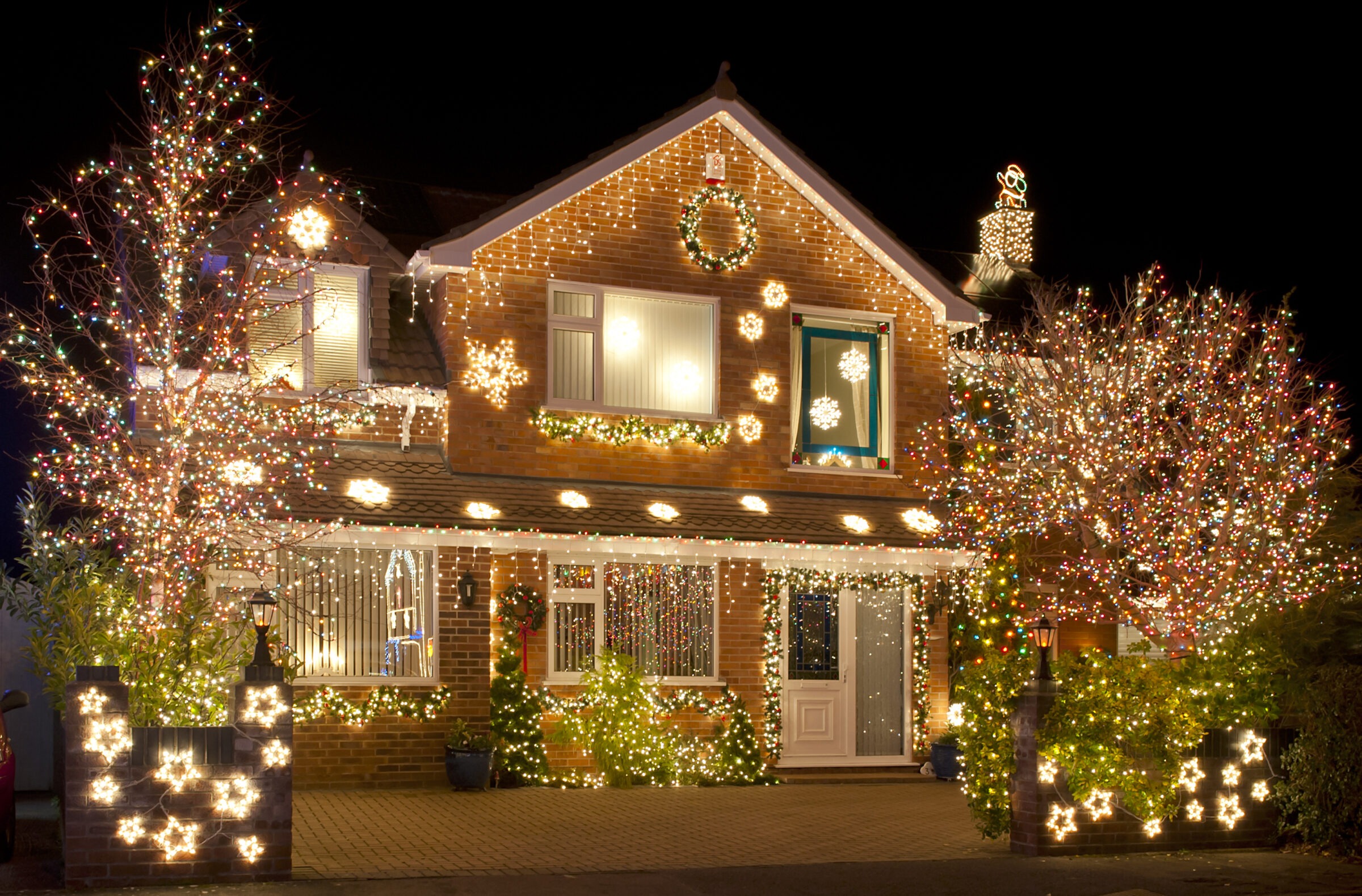 House adorned with colorful Christmas lights at night.