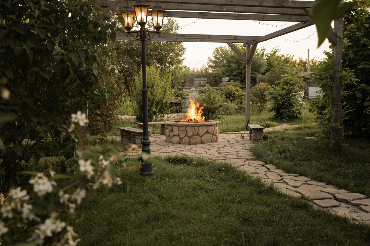 Garden pergola with fire pit and lamppost.